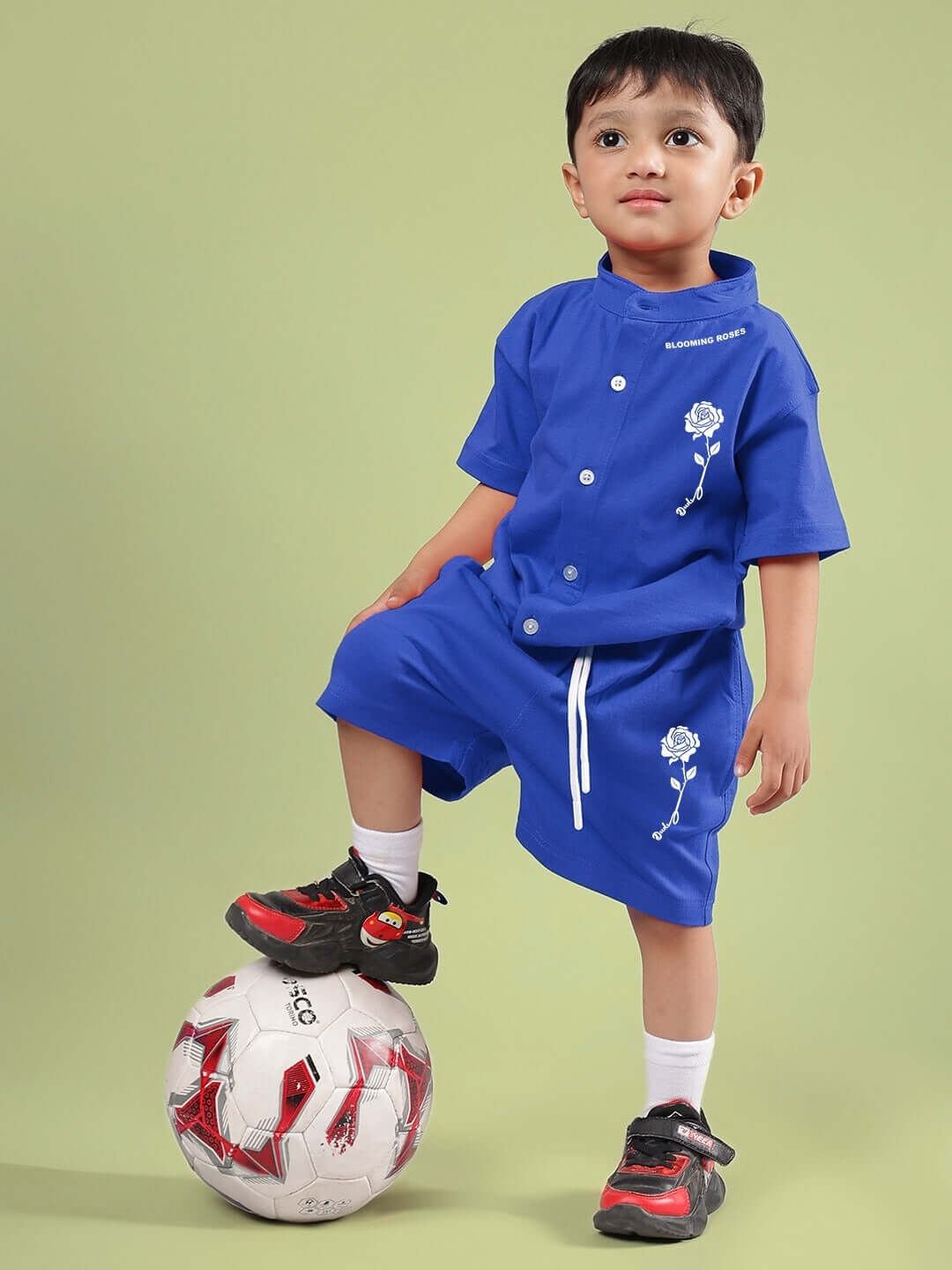 Child wearing LIMBO SHORTS FOR BOYS & GIRLS BLUE, standing confidently with a soccer ball; perfect for active play and casual style.