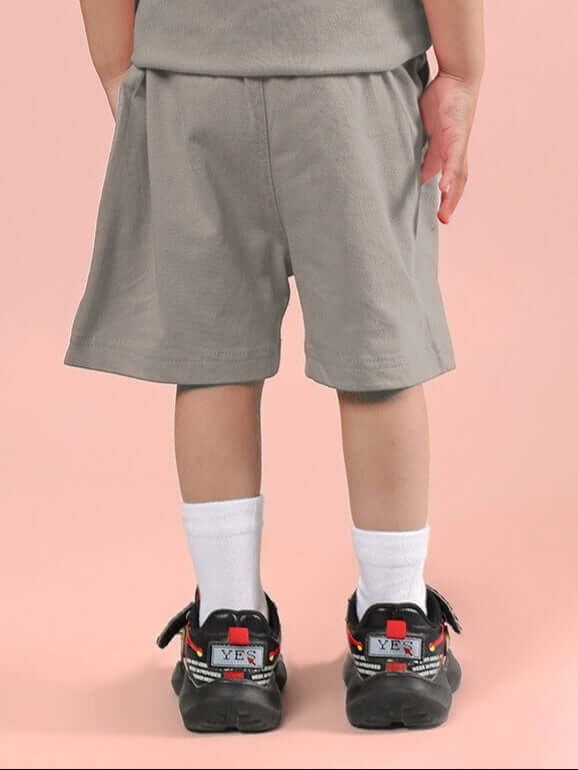 Child wearing LIMBO SHORTS FOR BOYS & GIRLS GREY showing back view with comfortable fit and breathable fabric, ideal for active kids.