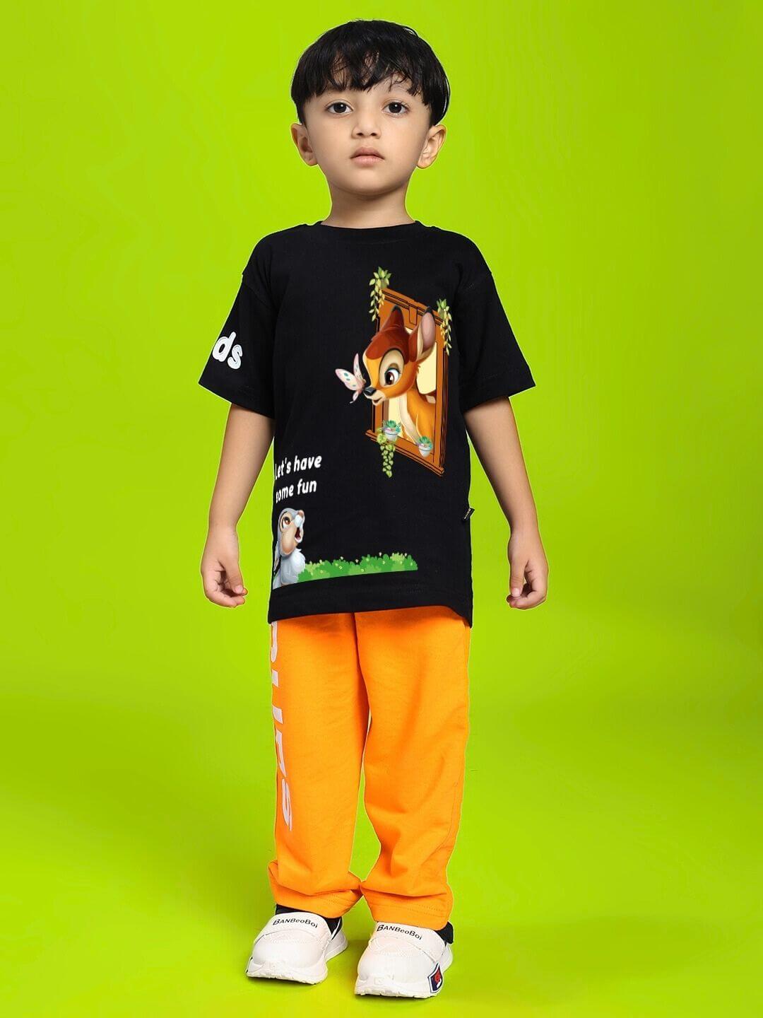 Child wearing LIMITED EDITION JOGGER FOR BOYS AND GIRLS ORANGE, standing on green background showcasing vibrant pants.