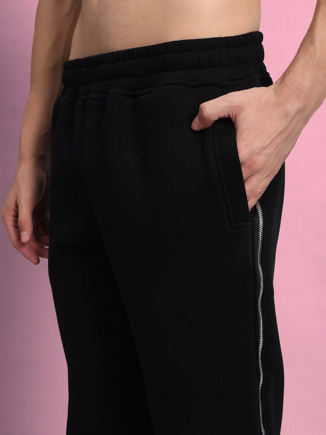 Close-up of LIMITLESS FLEECE REFLECTOR JOGGER BLACK with reflective detailing and tapered silhouette, showcasing streetwear style.