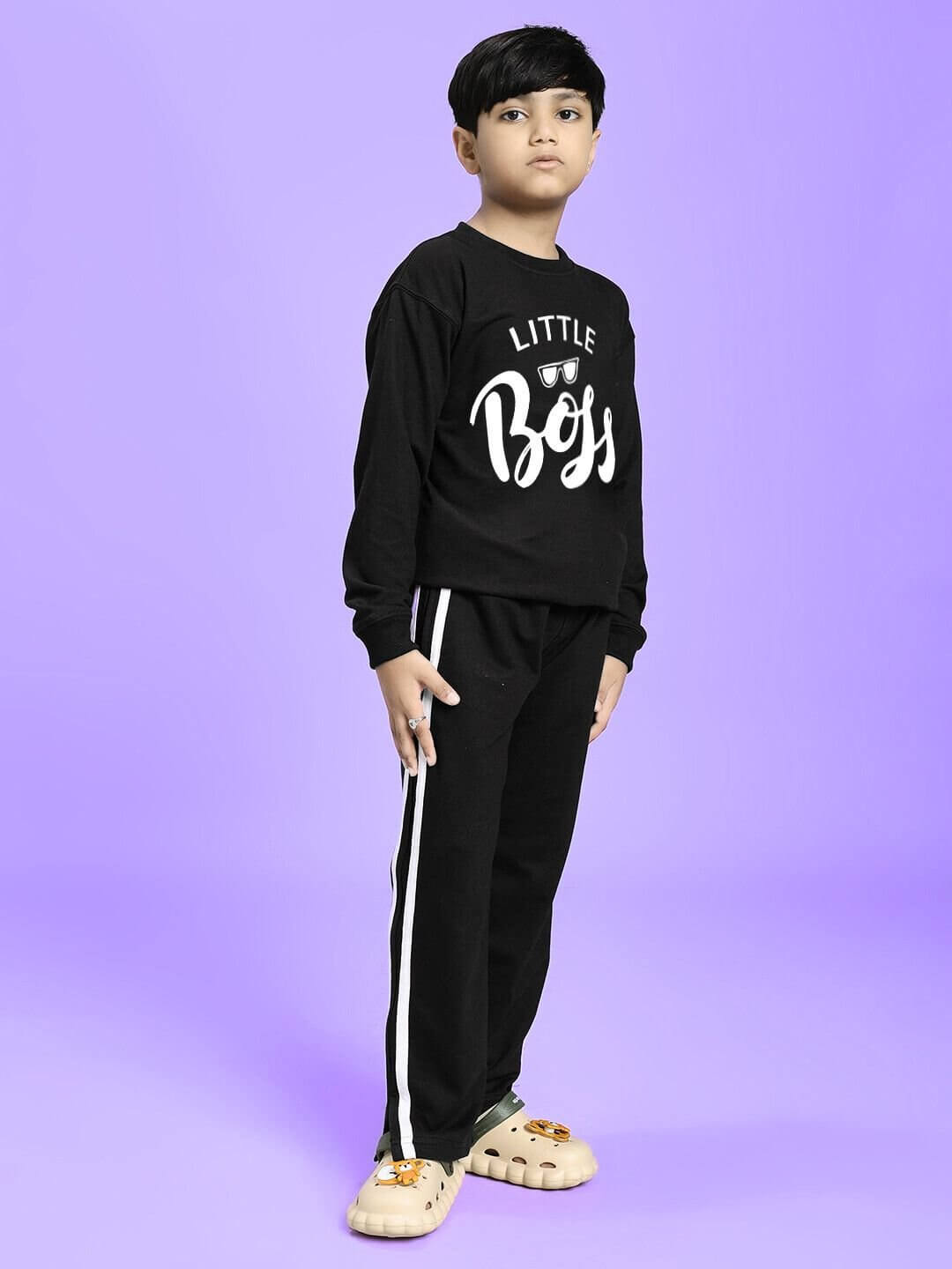 Child wearing LITTLE BOSS CO-ORD FOR BOYS AND GIRLS BLACK outfit with matching black top and pants, standing confidently against a purple background.