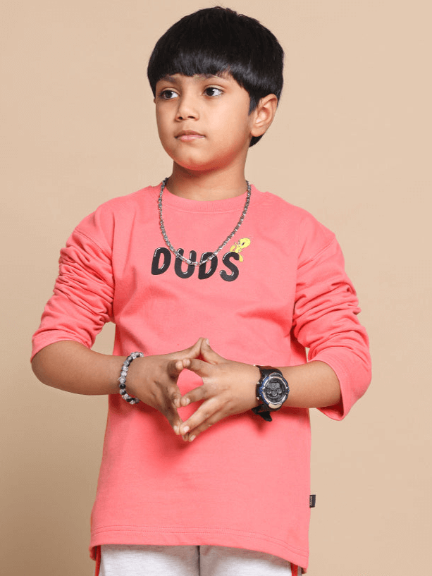 Young model wearing a peach oversized sweatshirt for boys and girls by DUDS, showcasing comfortable, stylish apparel for kids.