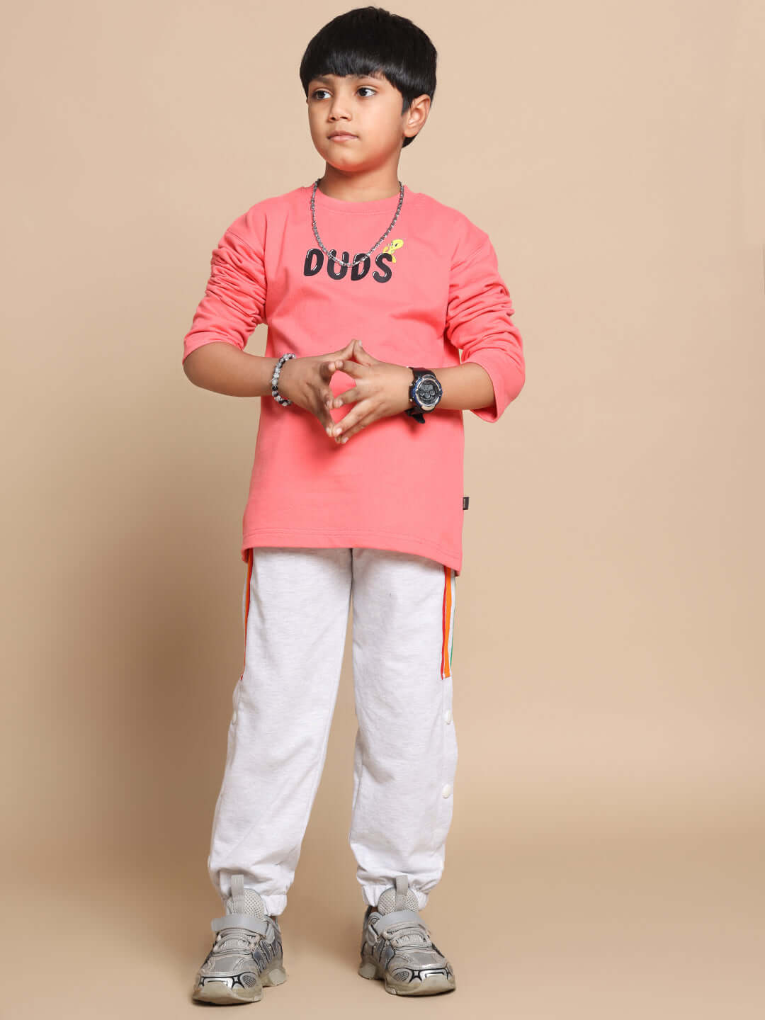 Child wearing Little Things Co-Ord in peach and grey by DUDS, featuring a peach top and grey joggers, perfect for boys and girls.