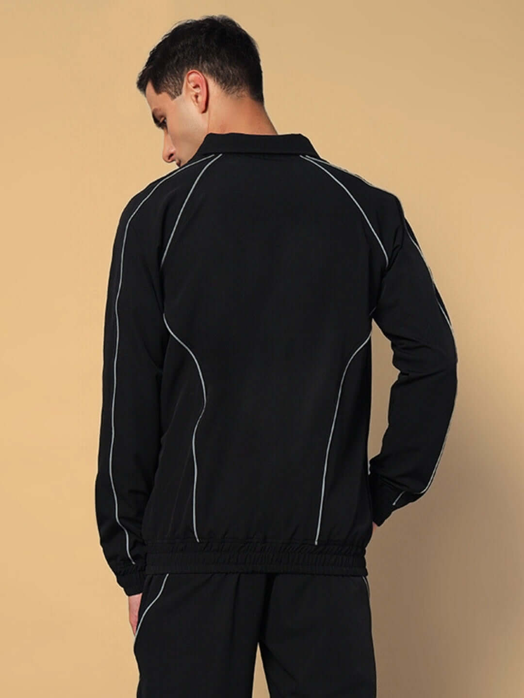 Back view of model wearing LOCO OVERSIZED CO-ORD SET BLACK with white piping, showcasing the trendy and comfortable streetwear design.