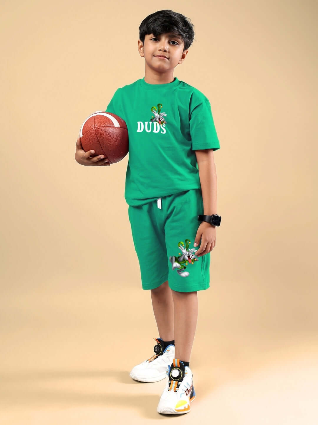 Young boy wearing LOONEY TUNES PRINTED CO-ORD FOR BOYS & GIRLS GREEN holding a basketball, showcasing custom fit clothing option.