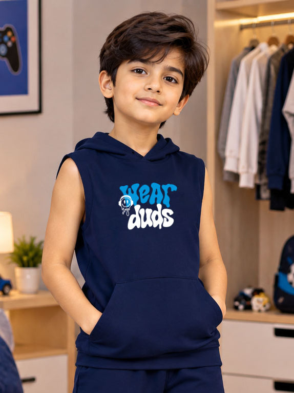LOUNGEWEAR SLEEVELESS HOODED T-SHIRT FOR KIDS NAVY BLUE worn by smiling boy in bedroom with closet in background