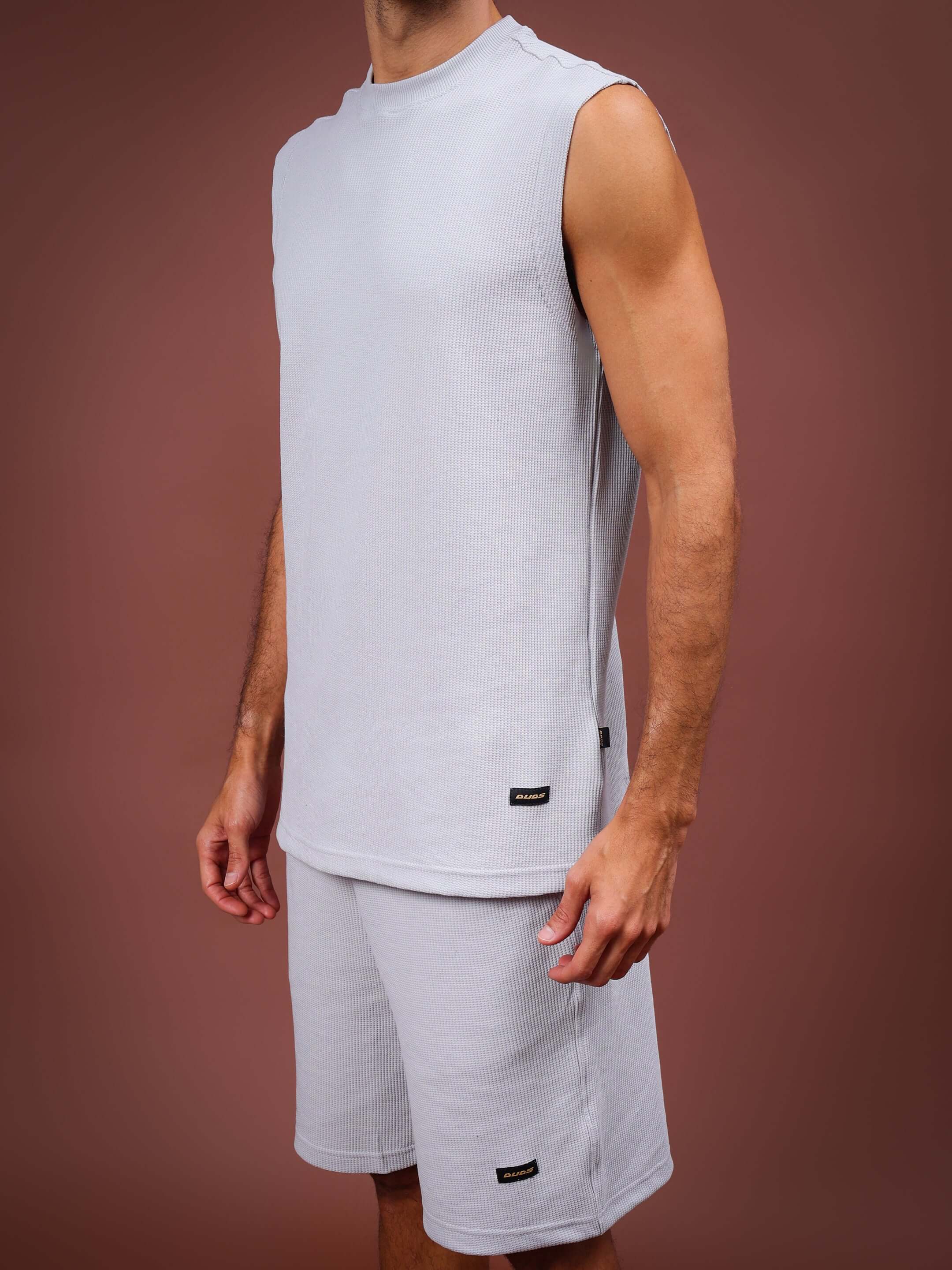 Low-key solid grey co-ord set in premium waffle fabric, featuring a sleeveless top and shorts, made from 100% cotton. Perfect for casual wear.