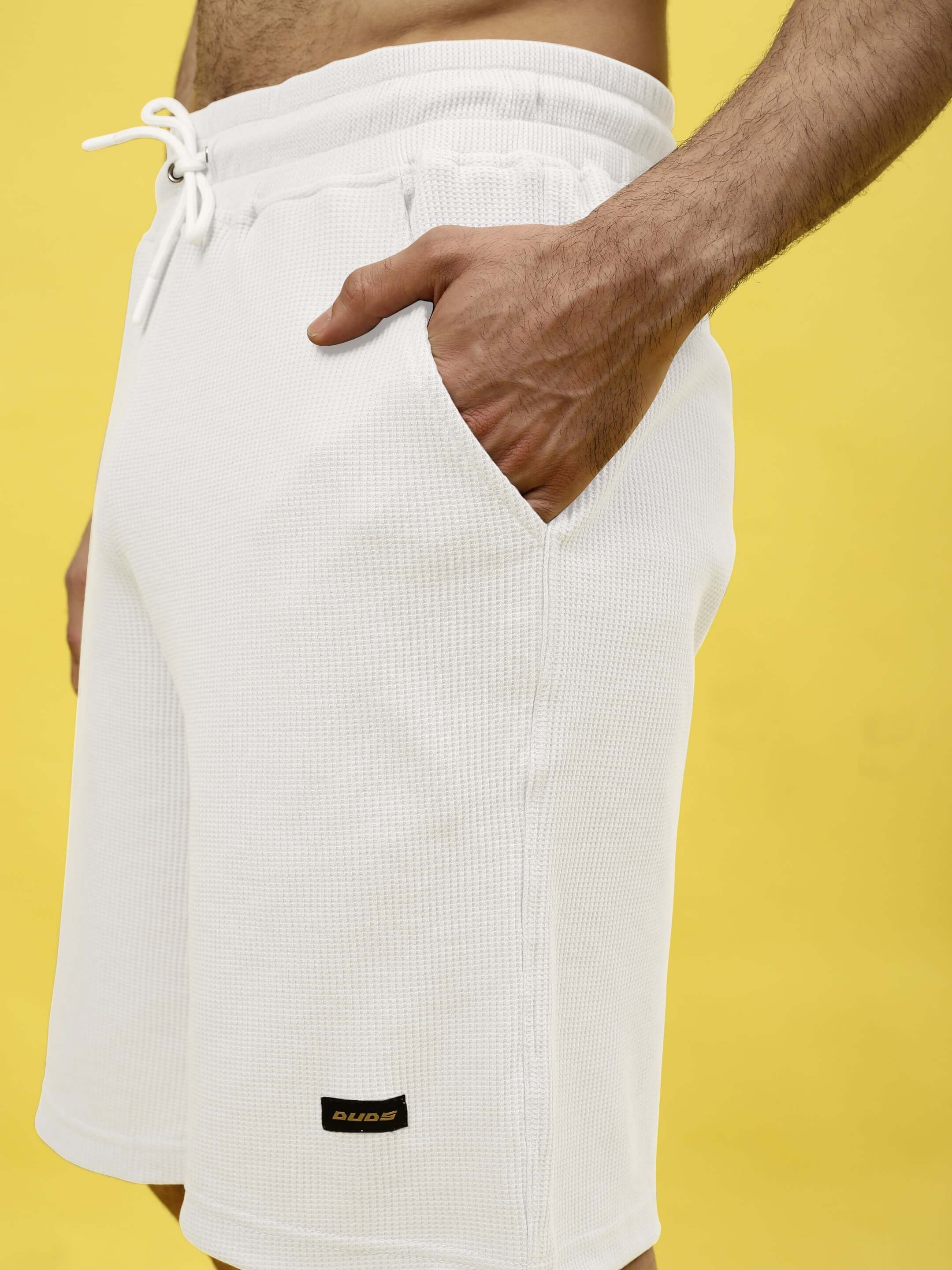 Close-up of off-white waffle knit shorts from Color By Colours, highlighting premium cotton fabric and drawstring detail.