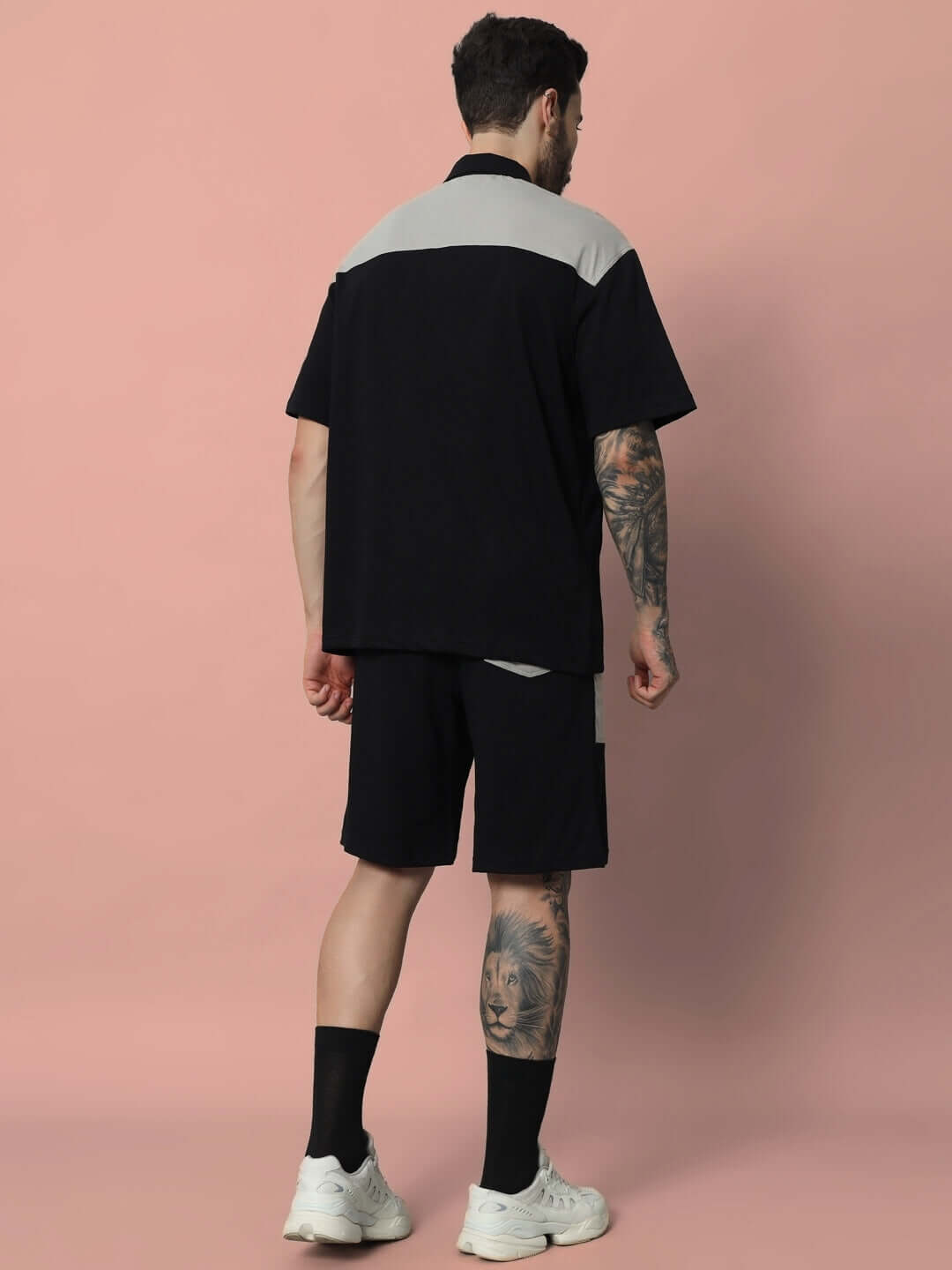 Model wearing black grey Lustre Co-ord set made of premium cotton French terry fabric, showcasing back view against a pink backdrop.