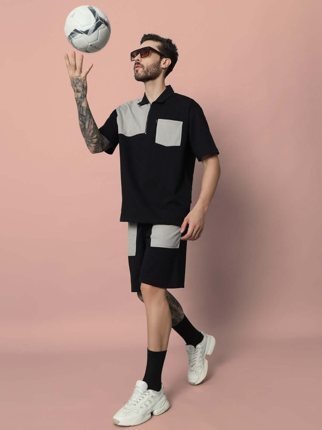 Man wearing a stylish black and grey Lustre Co-Ord Set, juggling a soccer ball. Made from premium cotton French terry lycra.