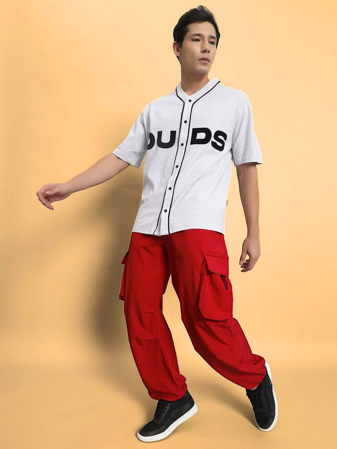 Model wearing MABEL relaxed fit cargo pants in red with a white DUDS shirt, showcasing comfortable and stylish design.