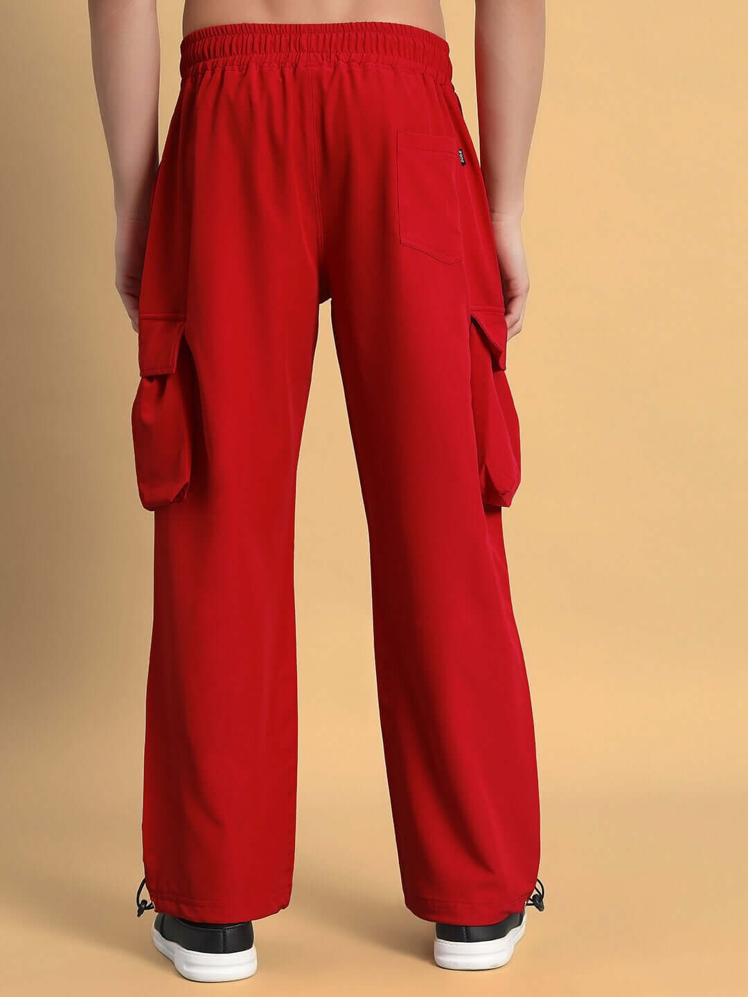 Back view of red MABEL relaxed fit cargo pants with elastic waistband and large side pockets.