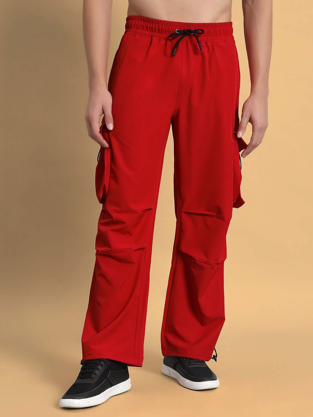 Model wearing Mabel Relaxed Fit Cargo Pants in red with drawstring waist and multiple pockets.