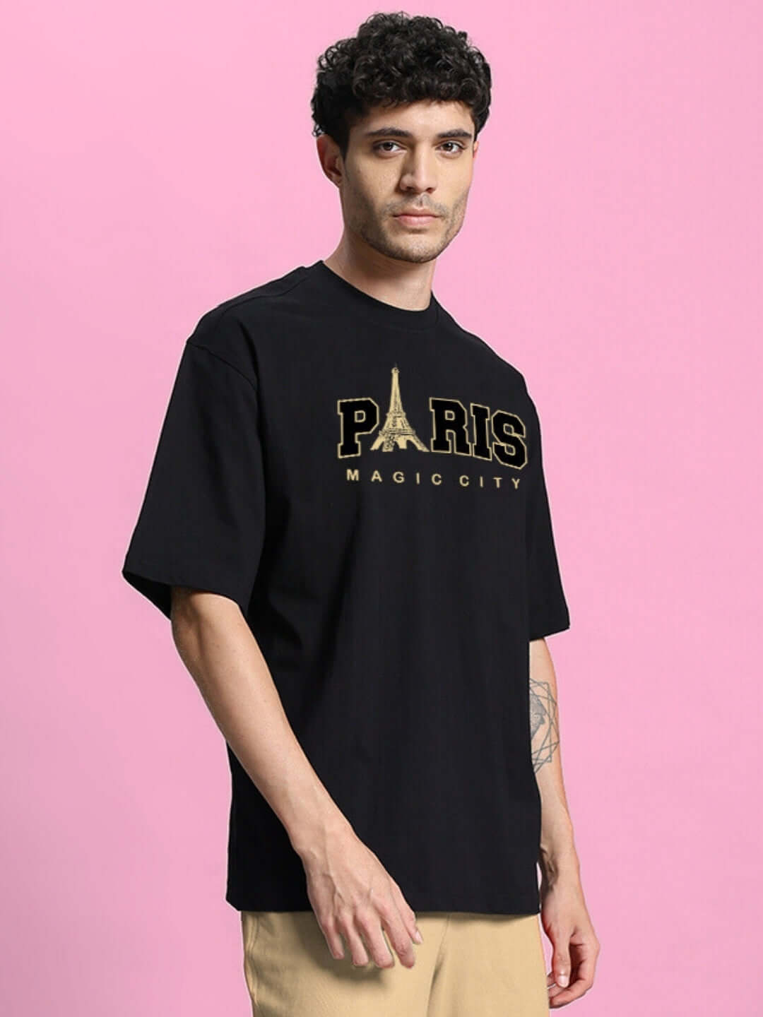 Person wearing MAGIC CITY OVERSIZED T-SHIRT BLACK with Paris graphic, made from premium 100% cotton heavy gauge fabric, bio-washed for comfort.
