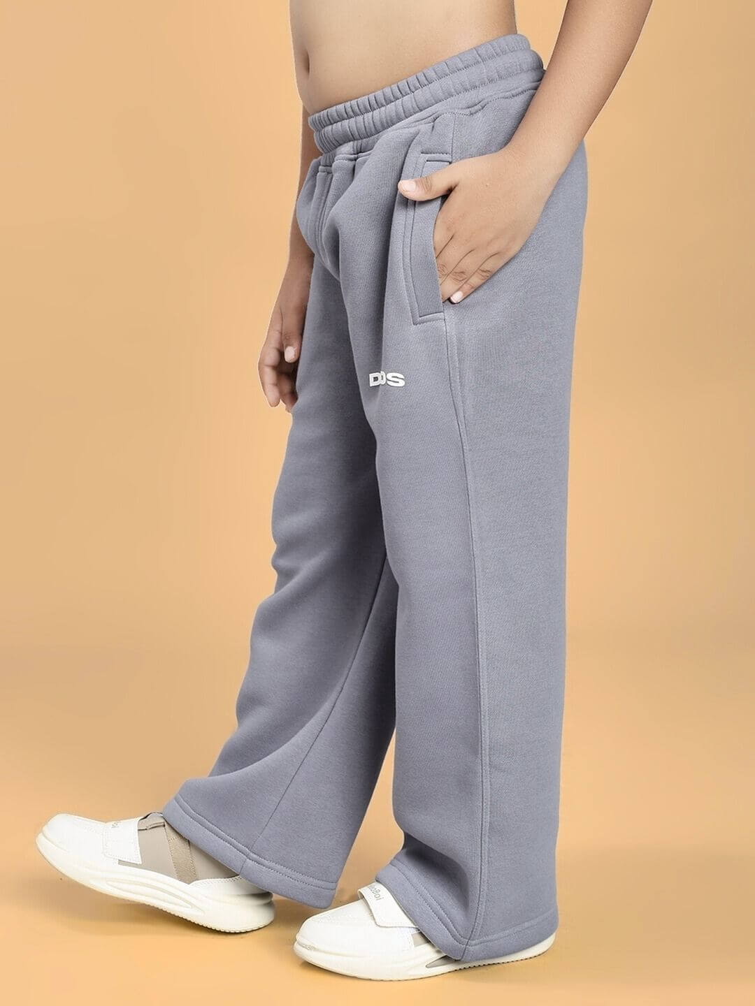 Child wearing MAKE IT HAPPEN FLEECE CO-ORD FOR BOYS AND GIRLS GREY pants, showing side view with hands in pockets. Cozy and stylish outfit.