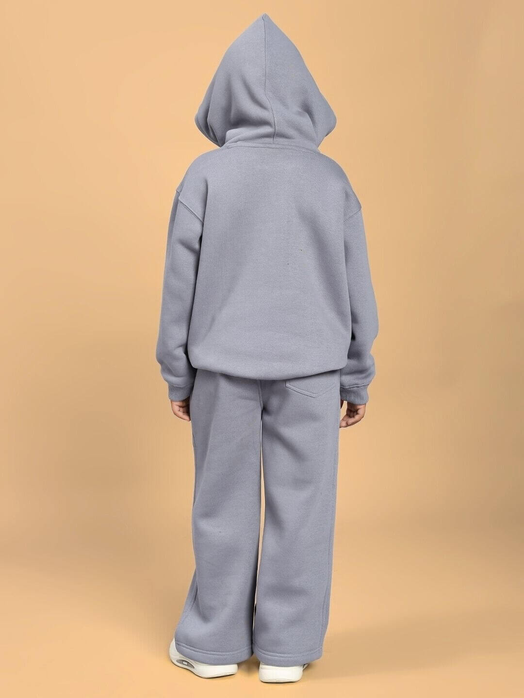 Child wearing MAKE IT HAPPEN FLEECE CO-ORD FOR BOYS AND GIRLS GREY, back view, showcasing cozy two-piece outfit with hood and pants.