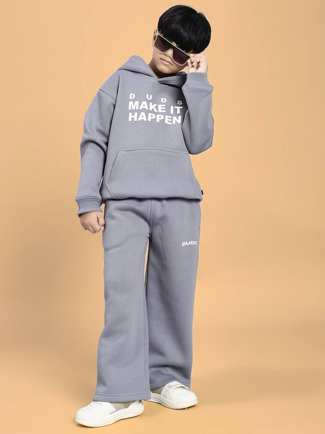 Child wearing MAKE IT HAPPEN FLEECE CO-ORD FOR BOYS AND GIRLS GREY outfit, showcasing cozy hooded sweatshirt and matching pants.