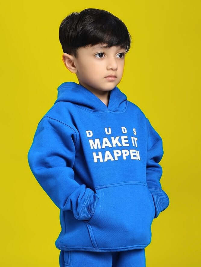 Child wearing MAKE IT HAPPEN FLEECE HOODIE FOR BOYS AND GIRLS ROYAL BLUE on yellow background; cozy, stylish, unisex clothing.