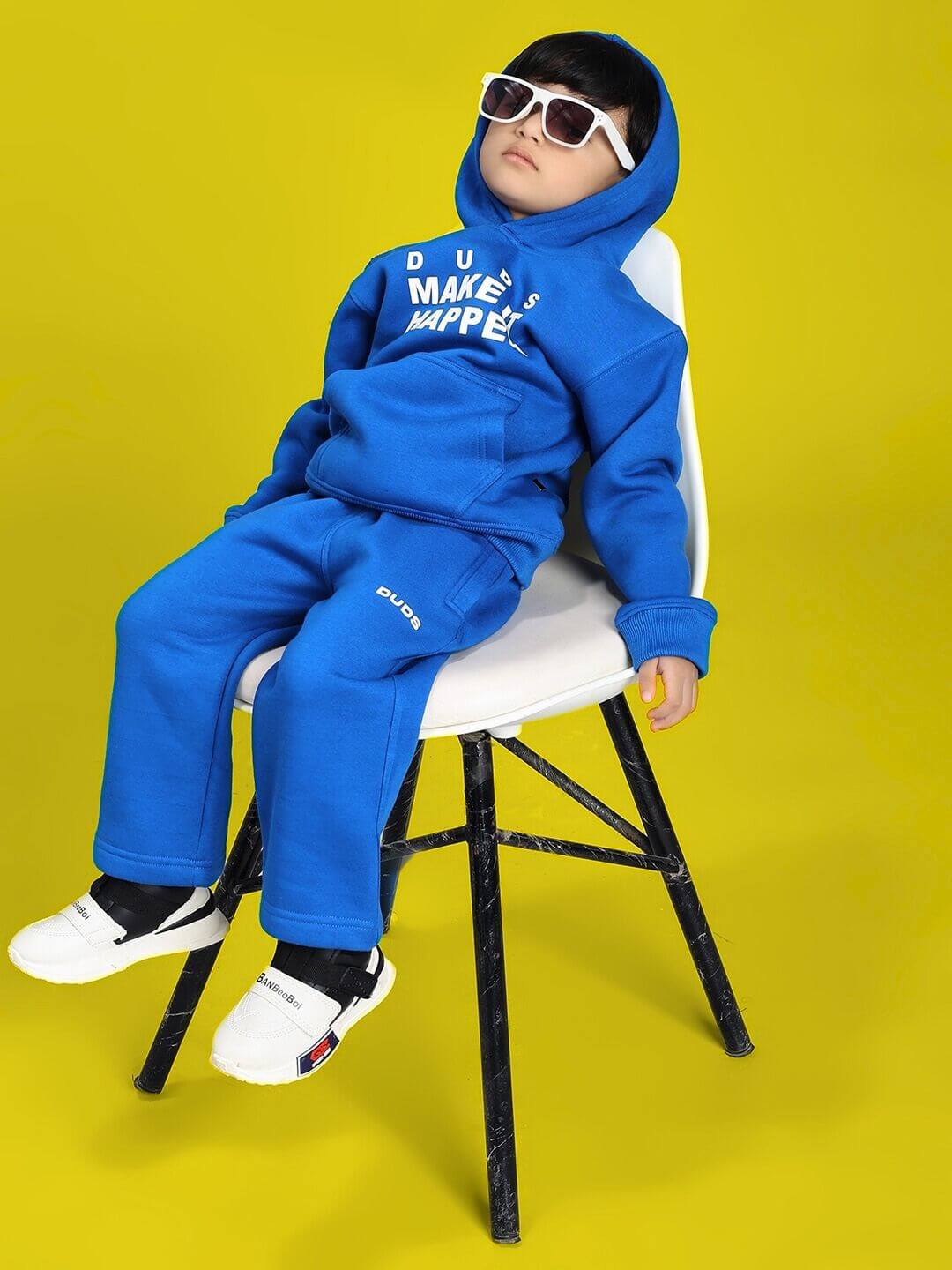 Child wearing MAKE IT HAPPEN FLEECE HOODIE FOR BOYS AND GIRLS ROYAL BLUE sitting on chair with sunglasses