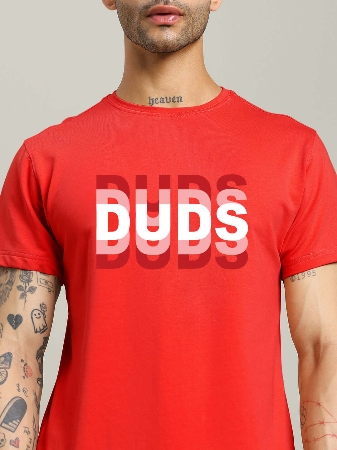 Person modeling MARK REGULAR FIT COTTON T-SHIRT RED with bold 'DUDS' graphic, showcasing casual style.