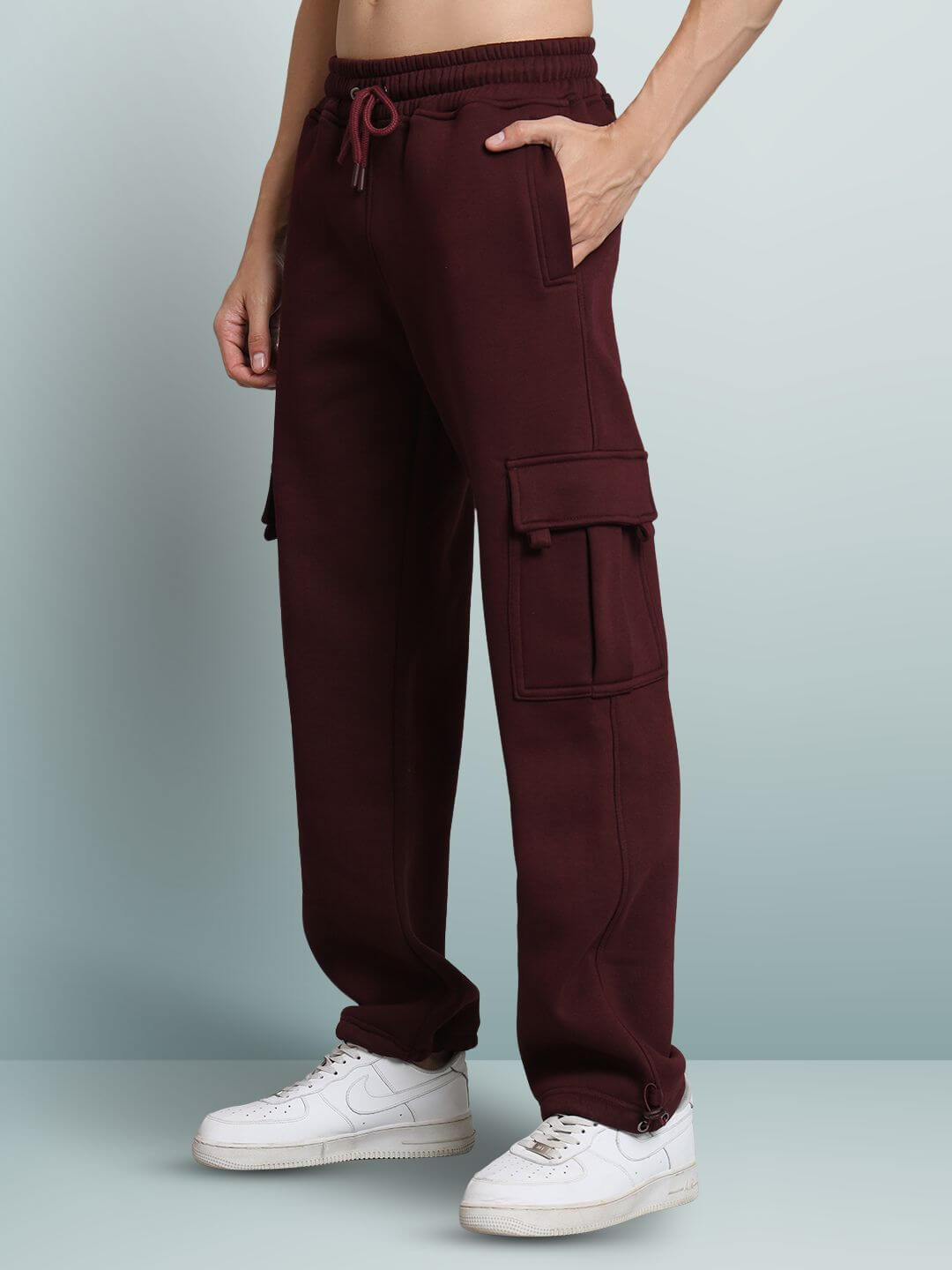 Maroon relaxed fit cargo fleece pants with side pockets, worn with white sneakers.