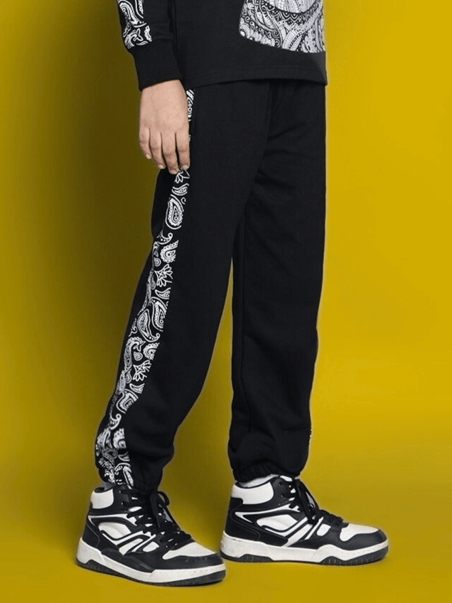 Child wearing black MASHA joggers with paisley design, featuring comfortable fit and style for boys and girls.