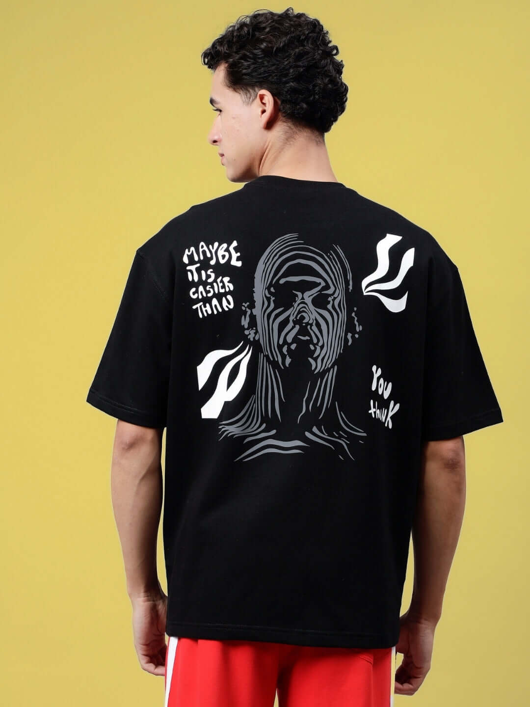Back view of a black oversized t-shirt with a reflective graphic design and text "MAYBE IT IS EASIER THAN YOU THINK."