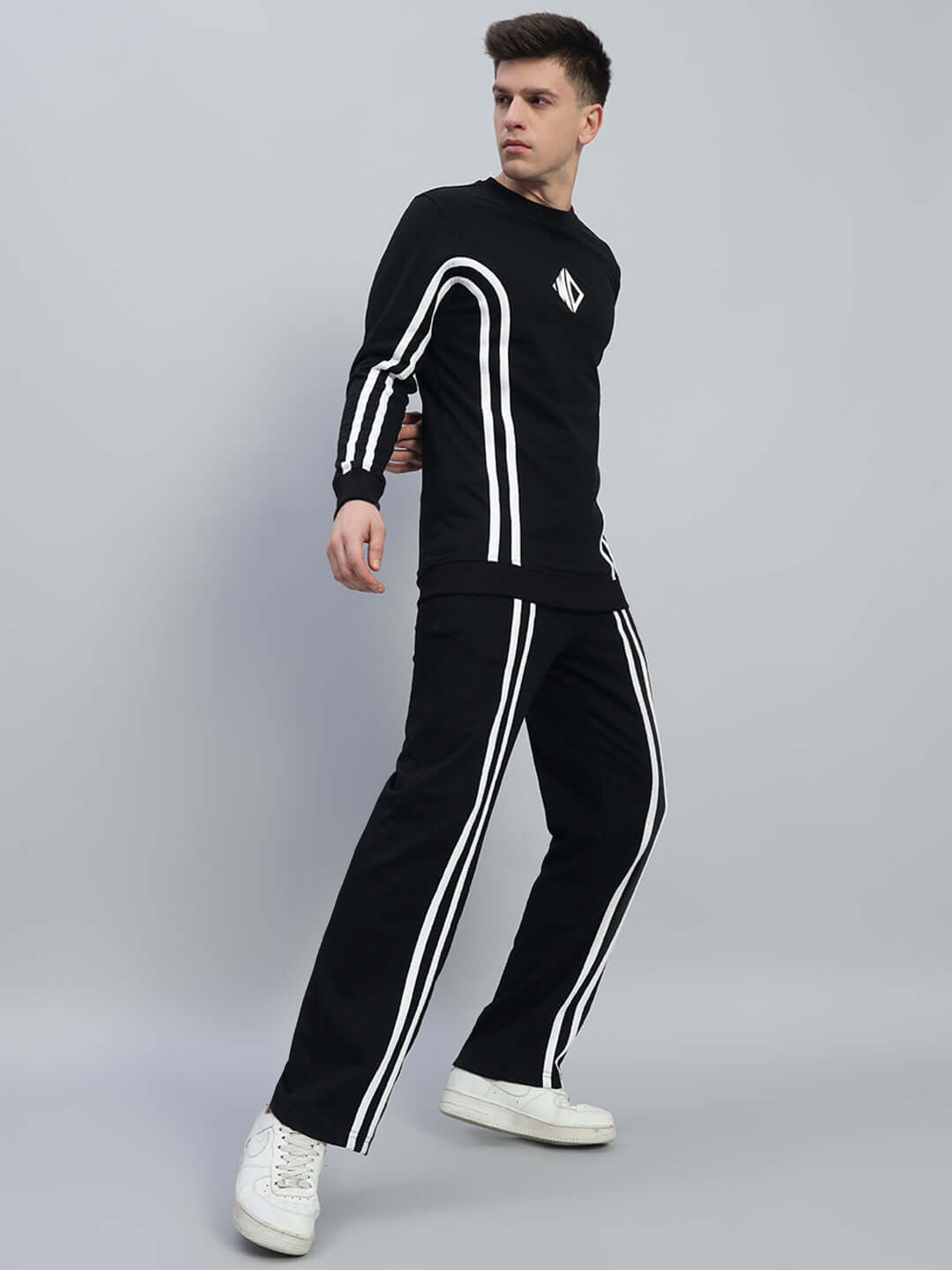 Unisex black co-ord set with white contrast panel, featuring relaxed fit joggers and elastic waistband, made of premium cotton blend.