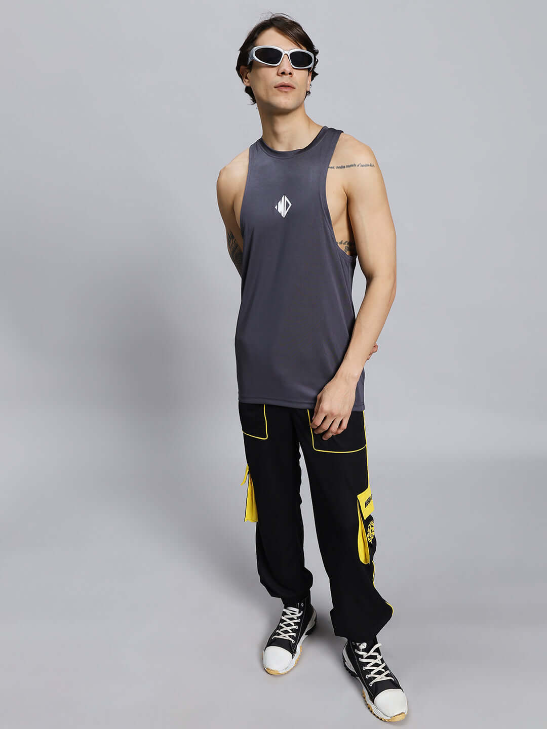 SOCCER REGULAR FIT CARGO JOGGER BLACK Model wearing black soccer regular fit cargo joggers paired with a sleeveless top and sunglasses, showcasing casual street style.