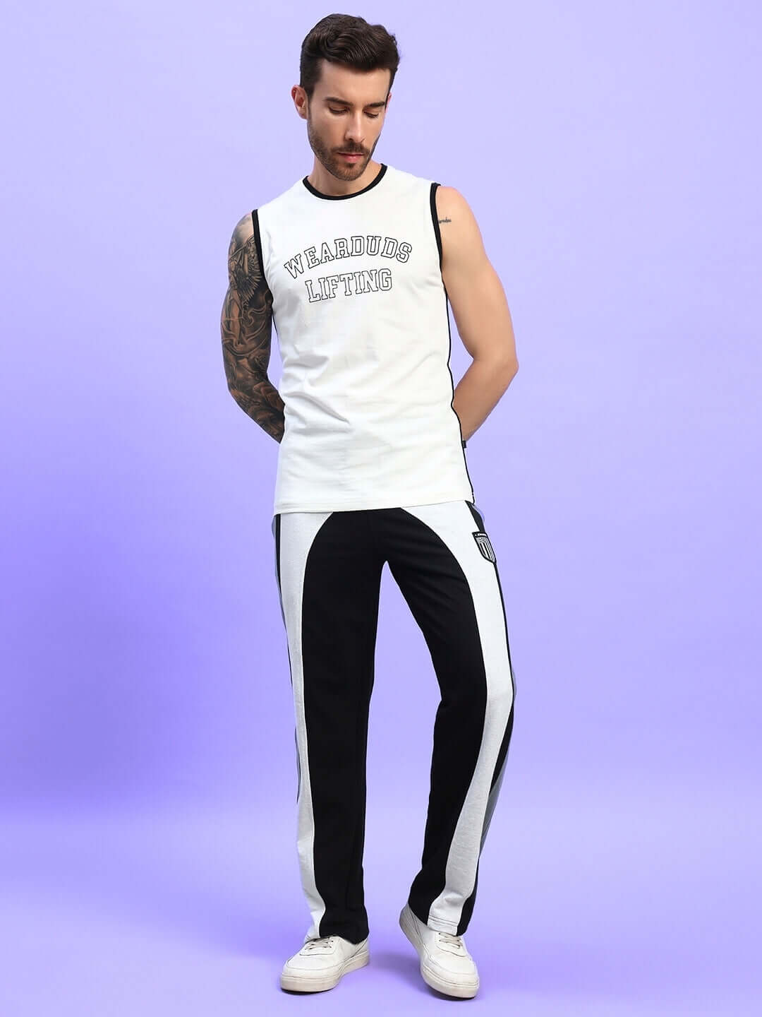 Model wearing LIFT UP REGULAR FIT T-SHIRT OFF WHITE paired with black and white pants, showcasing casual streetwear style against a pastel background.