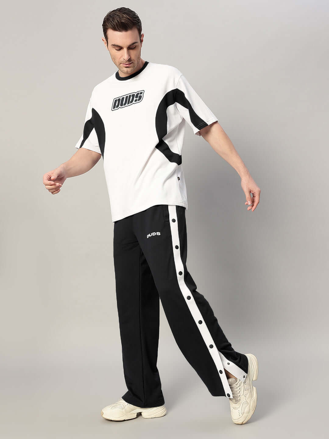 Model wearing EZEL Relaxed Fit Jogger in black, styled with a white DUDS t-shirt, showcasing comfortable fashion.