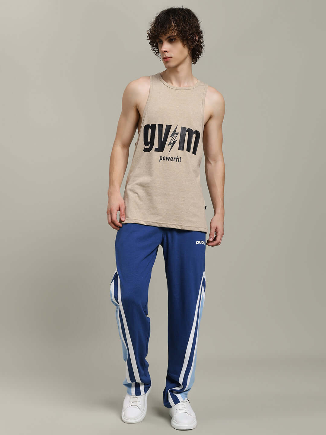 Man wearing RIO ONE Relaxed Fit Joggers in blue with a sleeveless gym shirt, showcasing casual athletic style.