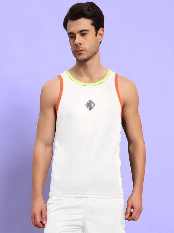 Man wearing white athletic tank top with neon accents and gym shorts, standing against a purple background.