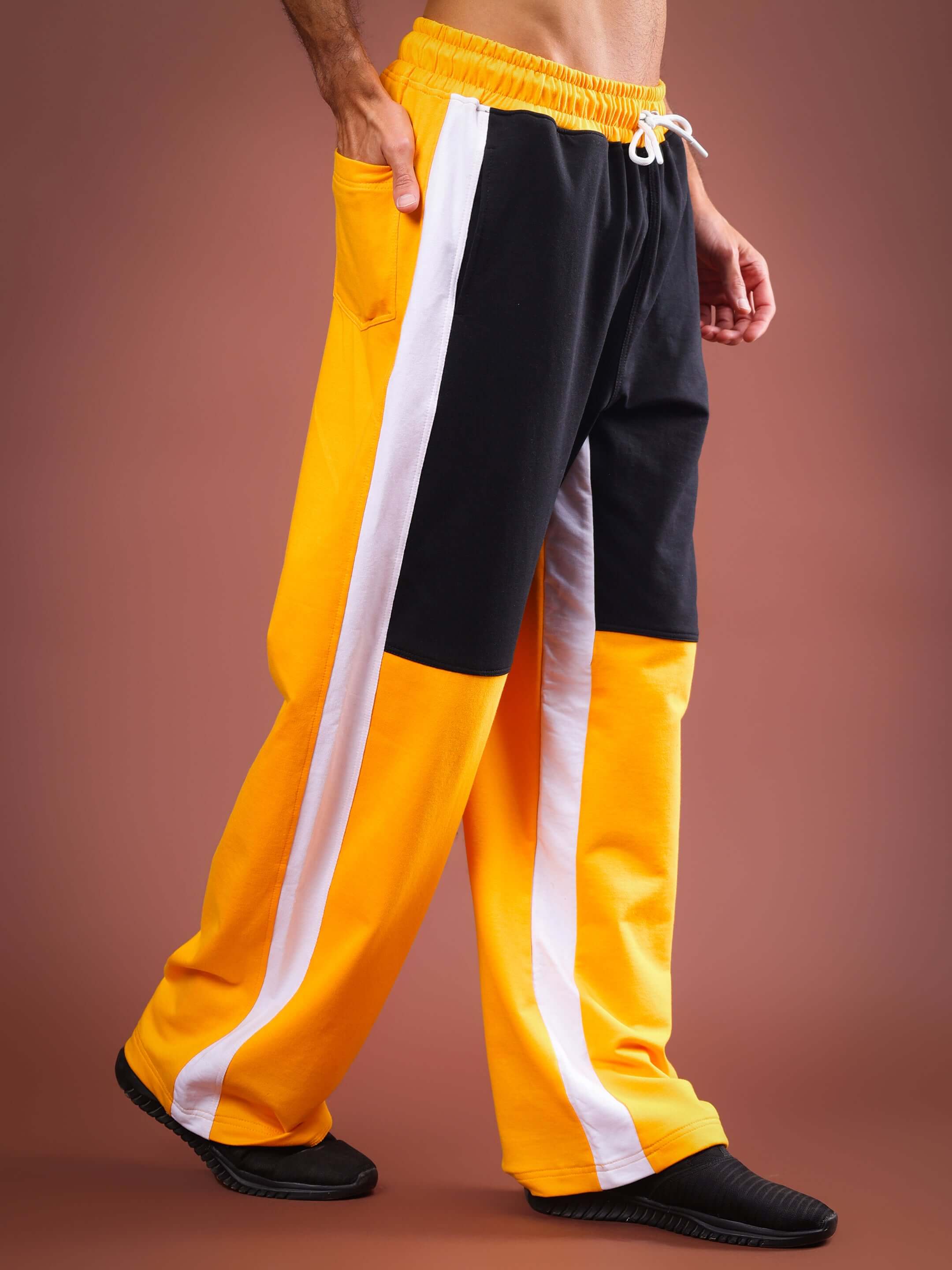 Yellow and black baggy joggers with white stripe, made to order by DUDS. Custom fit available. Shipping in 7-10 days.