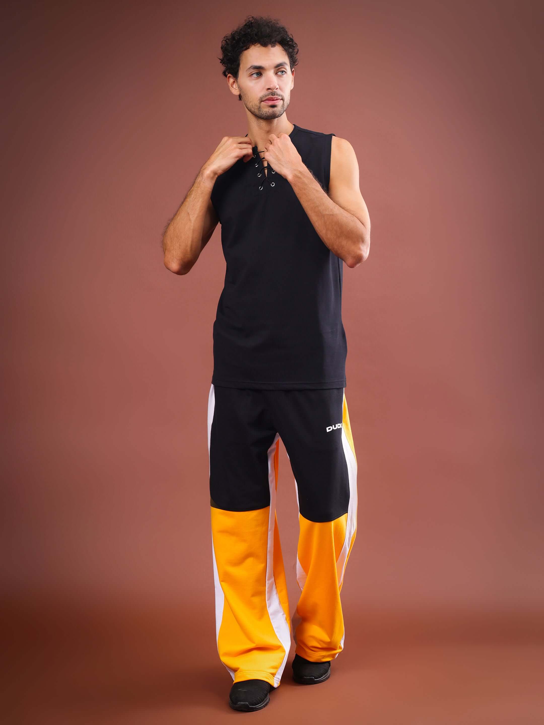 Model wearing Meraki Baggy Joggers in yellow-black with a sleeveless black top, showcasing made-to-order style.