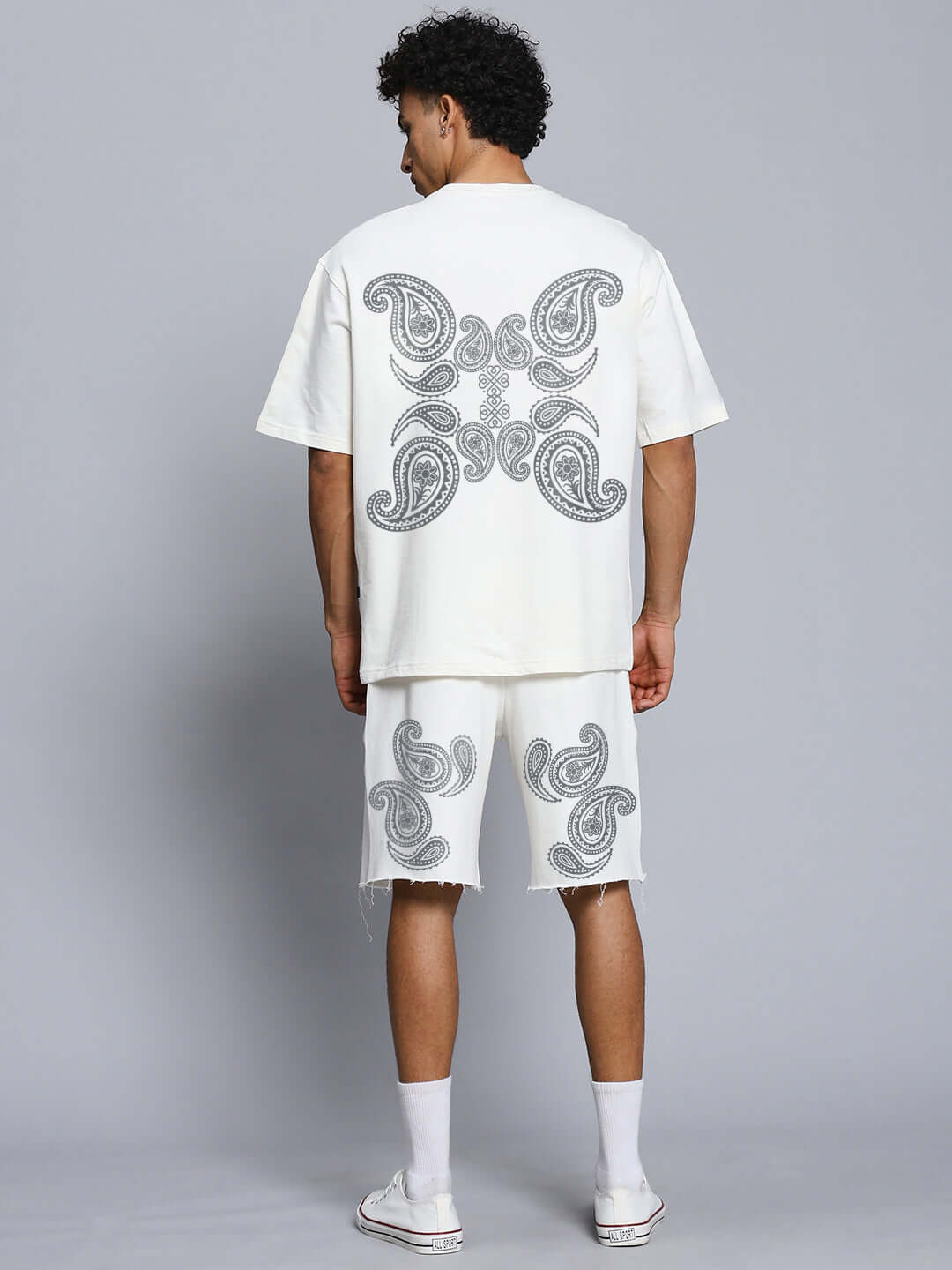Back view of model wearing MESSI PAISLEY PRINT CO-ORD SET OFF WHITE with paisley print, showcasing t-shirt and shorts