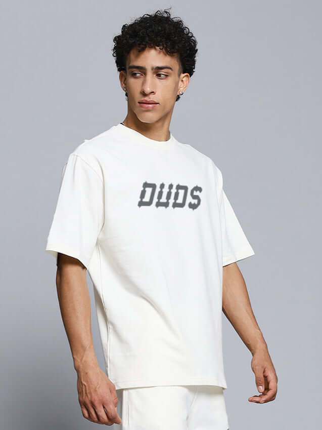 Man wearing MESSI PAISLEY PRINT OVER-SIZED T-SHIRT OFF WHITE, displaying a casual and stylish look on a plain background.
