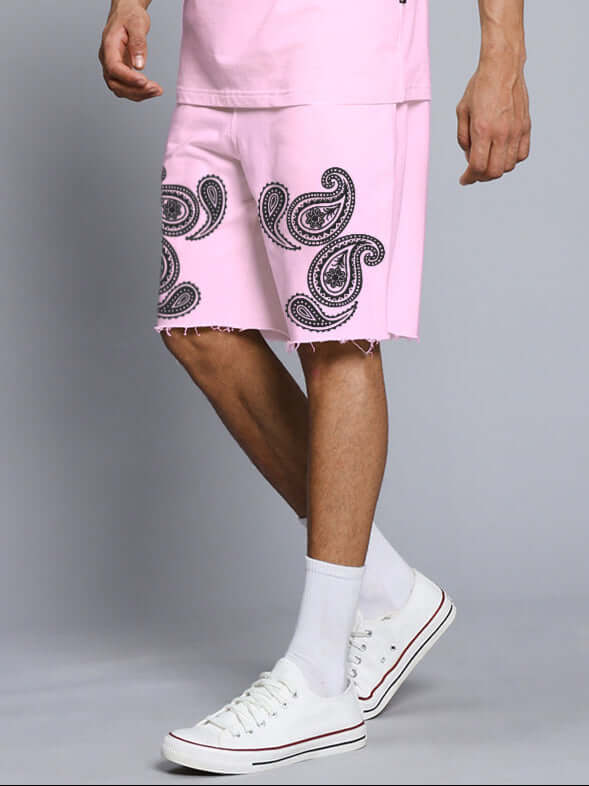 Man wearing MESSI PAISLEY PRINT REGULAR FIT SHORTS PINK with white sneakers and socks, showing the intricate paisley design.
