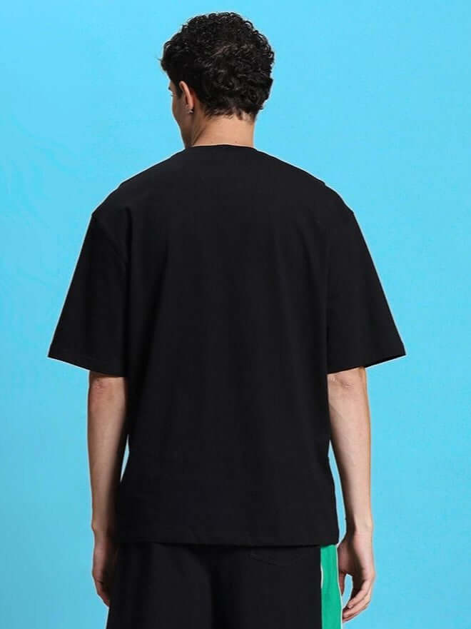 Back view of METEORIC OVER-SIZED T-SHIRT BLACK, showcasing its relaxed streetwear style, made from premium-quality cotton fabric for comfort.
