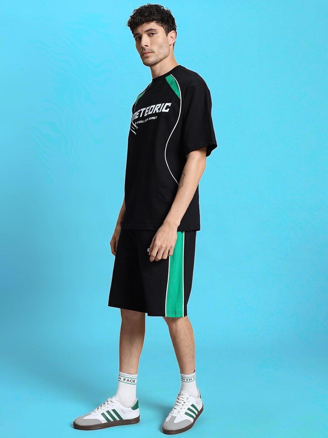 Model wearing METEORIC REGULAR FIT SHORTS BLACK by WEAR DUDS against a blue background.