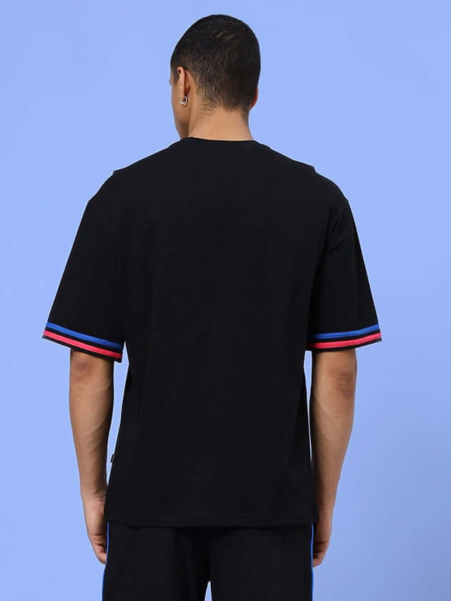Back view of MIAMI OVER-SIZED T-SHIRT BLACK with red and blue sleeve accents, showcasing the relaxed fit for casual style.