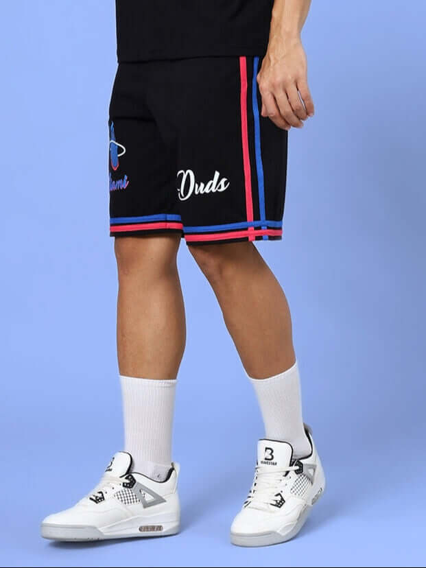 Man wearing MIAMI REGULAR FIT SHORTS BLACK, paired with white sneakers and socks, showcasing casual style and comfort.
