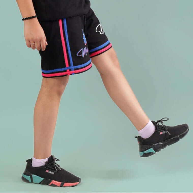 Child wearing MIAMI SHORTS FOR BOYS & GIRLS BLACK with colorful stripes, showcasing casual fashion and comfort.