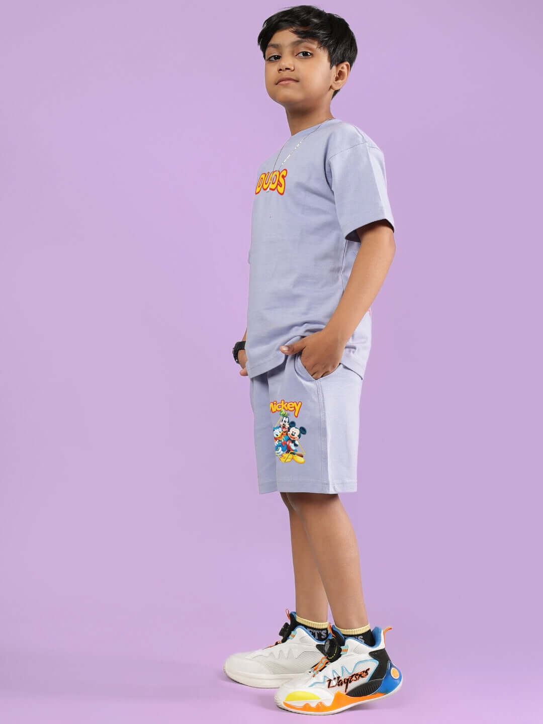Boy modeling the MICKEY DINGO CO-ORD FOR BOYS & GIRLS LAVENDER outfit with vibrant sneakers on a lavender background.