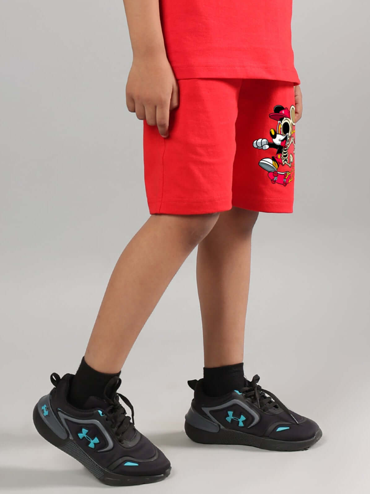 Child wearing Mickey Mouse red summer shorts, featuring vibrant fabric and playful design. Perfect casual wear for boys and girls.