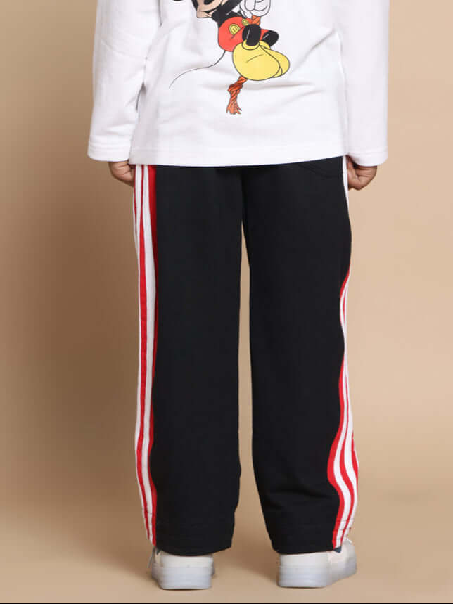 MILANO RELAXED PANT FOR BOYS & GIRLS JOGGER BLACK RED Child wearing black and red MILANO RELAXED PANT, jogger style, by DUDS, with white shoes and a character-themed shirt.