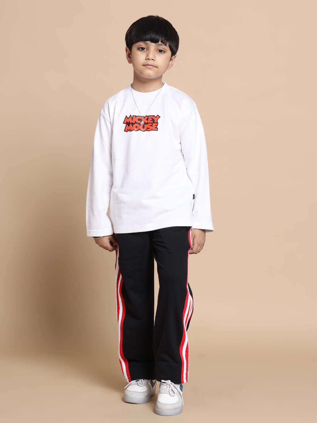 Child wearing Mickey Mouse shirt and black pants with red stripes, casual outfit for kids.