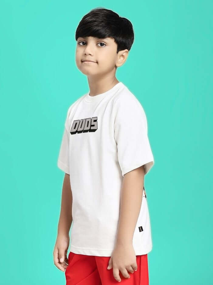 Child wearing MINECRAFT T-SHIRT FOR BOYS GIRLS WHITE with red shorts on turquoise background