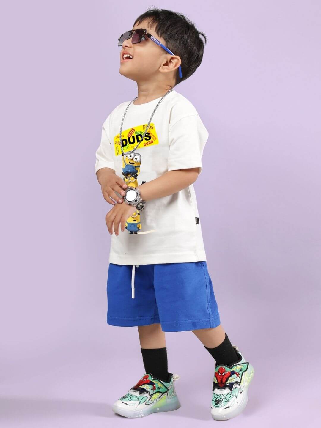 Child wearing Minion Cartoon Co-ord for Boys and Girls Off White-Black, smiling, vibrant style with blue shorts and playful energy.