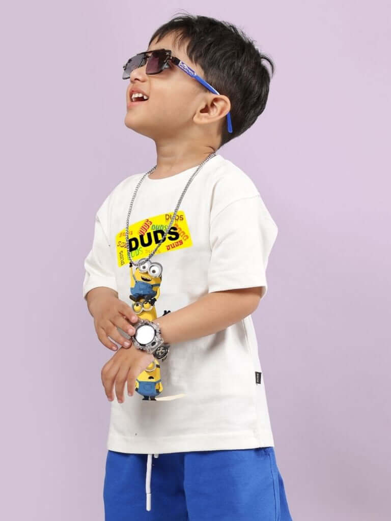 Boy wearing Minion Cartoon T-Shirt for Boys and Girls Off White, smiling and wearing sunglasses, purple background